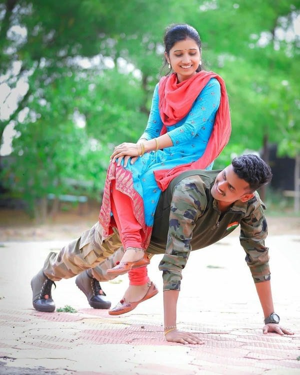 army couple dp in training ground holding hands.